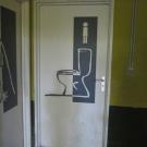 Elke deur wordt duidelijk gesignaleerd door een logo van de tak of een pictogram voor de functie van het lokaal vb. toilet voor jongens (Scouts Akabe Lint)