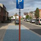 Op het openbaar domein is er een aangepaste parkeerplaats die duidelijk gesignaleerd is met een bord en een blauwe ondergrond. (Chiro Sint-Filippus, Schoten)