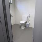 Het aangepast toilet is voorzien met twee zijdelinkse opstelruimtes. Optimaal is er aan beide zijden van het toilet een opklapbare beugel. (Jeugdhuis Sumo, Opglabbeek)