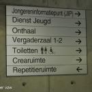 Van aan de toegang is er een duidelijke signalisatie naar de verschillende lokalen of ruimten. (Jeugdhuis Rondpunt 26, Genk)